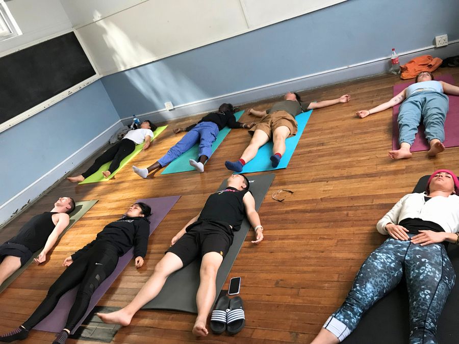 A yoga class resting on mats